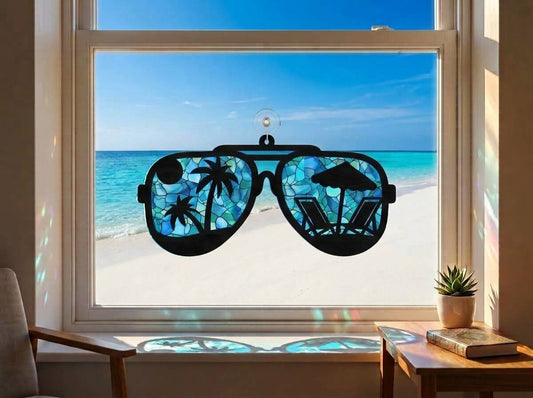 Sun Catcher Ochelari de Soare Tropicali pe geam, cu reflexii marine și peisaj de plajă exotică.
